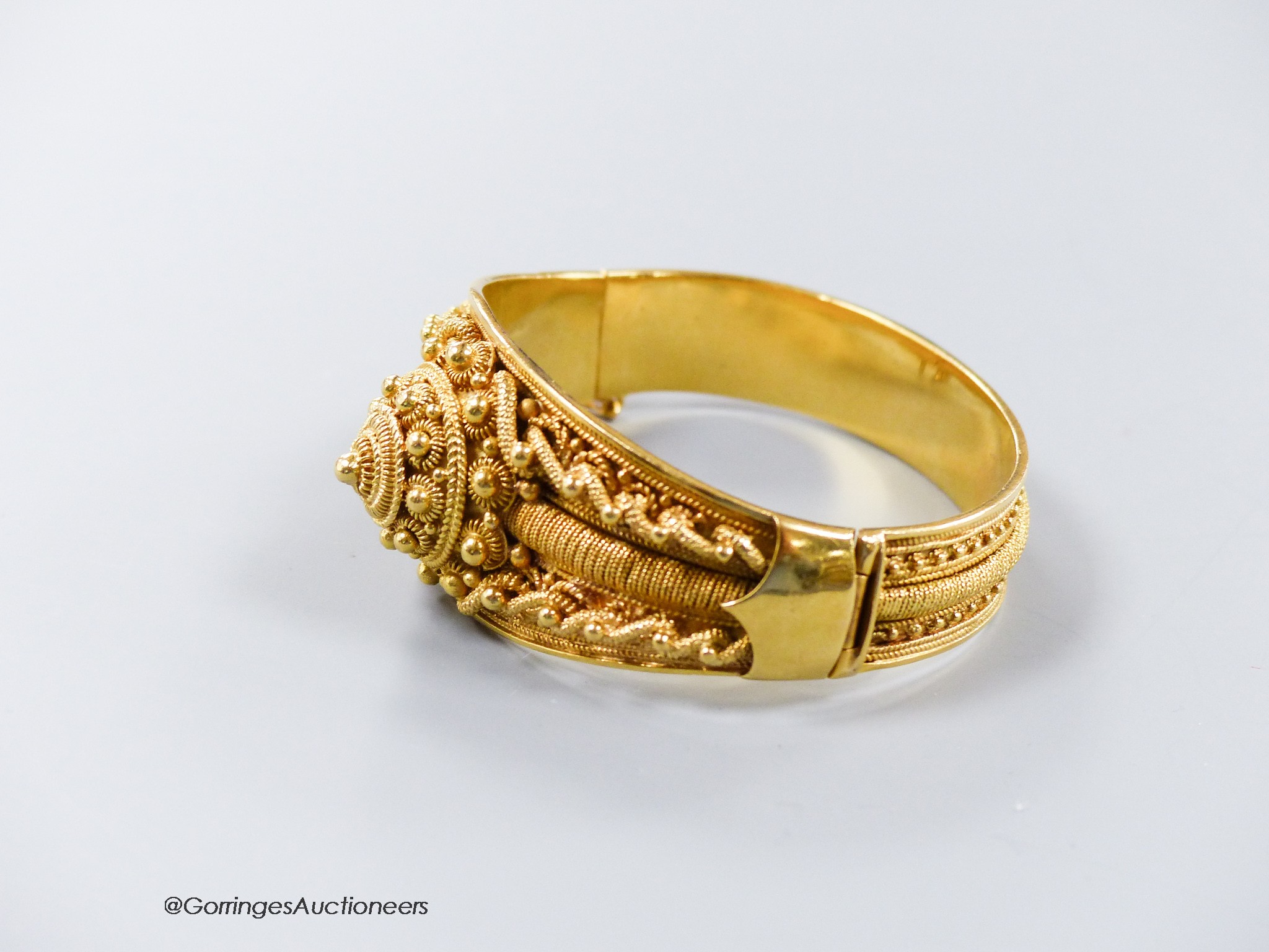 A 20th century Victorian style yellow metal (stamped 19k) cannetile work hinged bracelet, interior diameter 57mm, 60.1 grams.